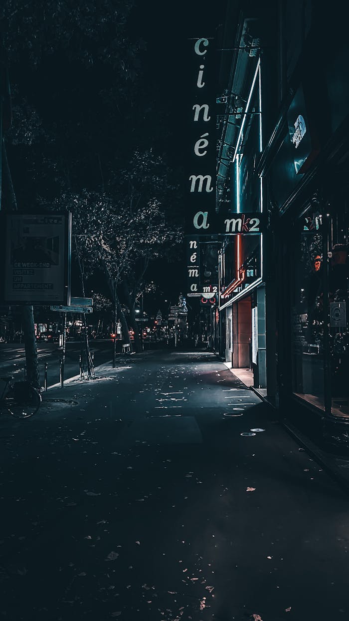 Atmospheric night street with cinema sign — illustrative editorial image